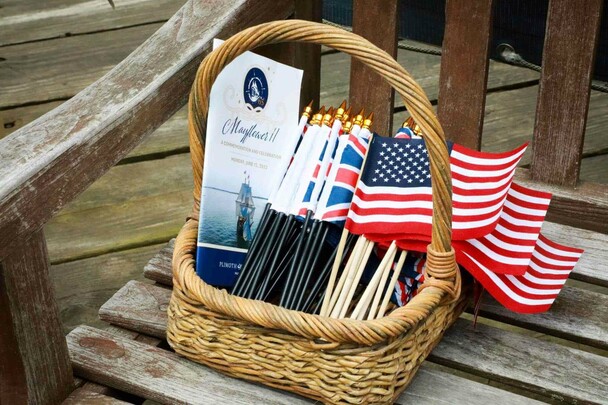 Basket of Mayflower II commemoration programs with US and UK flags.
