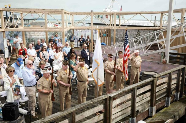 Veterans and guests stand for presentation of colors on dock at Mayflower II.