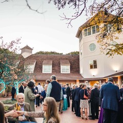 Museum guests gather for cocktail reception in courtyard.