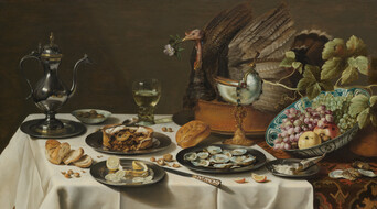 Lavish table setting with oysters on silver plates, a gleaming wine jug, olives, sliced lemons, and an imposing turkey with a flower in its beak.