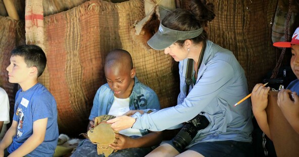 Students sit in a wetu with their teacher and learn about Wampanoag culture and lifeways.