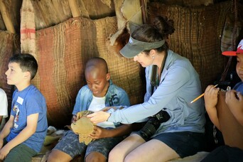 Students sit in a wetu with their teacher and learn about Wampanoag culture and lifeways.