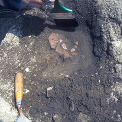 Archaeologists brush dirt from redware ceramic found at the Allerton-Cushman Site.