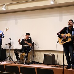 Three members of Lone Wolf and the Spaghetti Corner Band perform on stage.