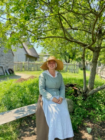Pilgrim woman seated in yard of pilgrim house
