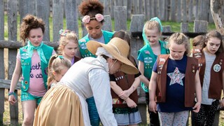 Girl Scouts learn in the 17th-Century English Village from a Pilgrim woman.