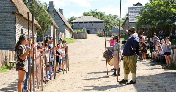 Guests line up in the English Village to assist Pilgrims with a pike drill.