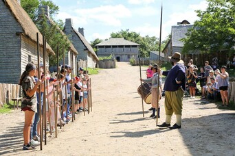 Guests line up in the English Village to assist Pilgrims with a pike drill.
