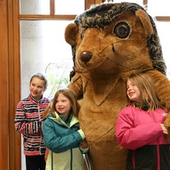 Hedgie poses for a photo with three young fans.