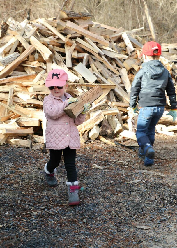 Children volunteers carry wood clean up day