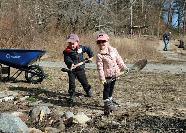 Young colunteers shoveling homesite clean up day