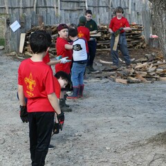 Young colunteers stacking wood line village clean up day