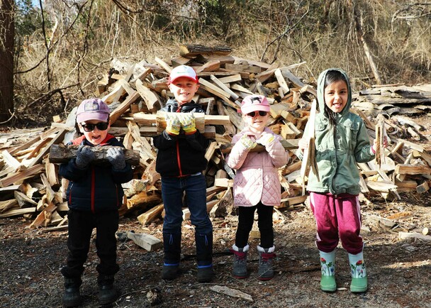 Young volunteers homesite stacking wood clean up day