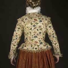 A woman models the back of the Plimoth Jacket and 17th century clothing.