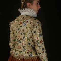 A woman models the Plimoth Jacket and 17th century clothing.