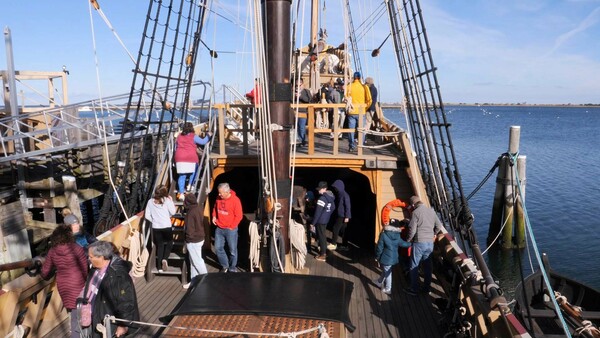 Museums guests walk around the decks of Mayflower II.