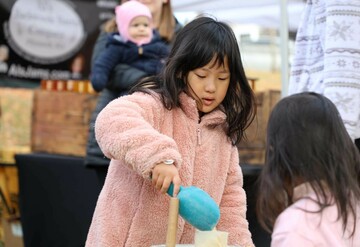 A girl grinds corn