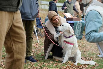 A woman pets a dog at Grain Fest.