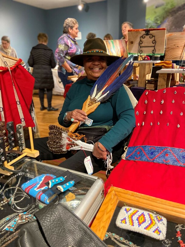 Indigenous Artisan Fellow displays her art in a crowded room at the Winter Fair.