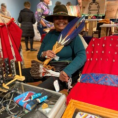 Indigenous Artisan Fellow displays her art in a crowded room at the Winter Fair.