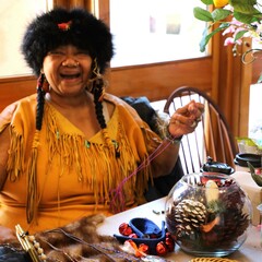 Indigenous Artisan Fellow sits at a table displaying her art and craft.