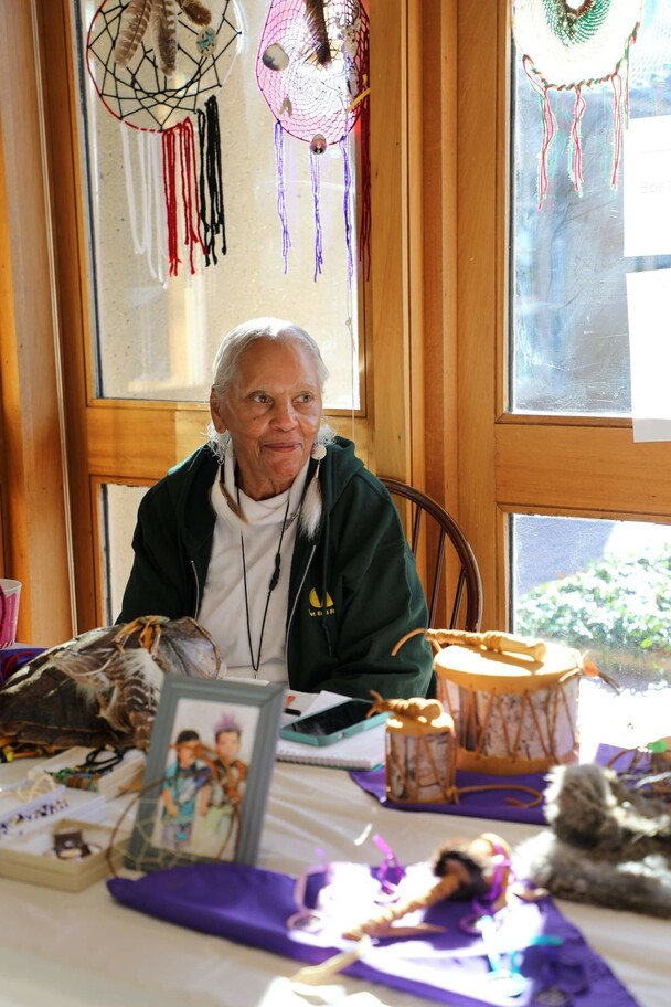 Indigenous Artisan Fellow seated at a table displaying her art.