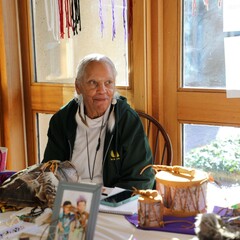 Indigenous Artisan Fellow seated at a table displaying her art.