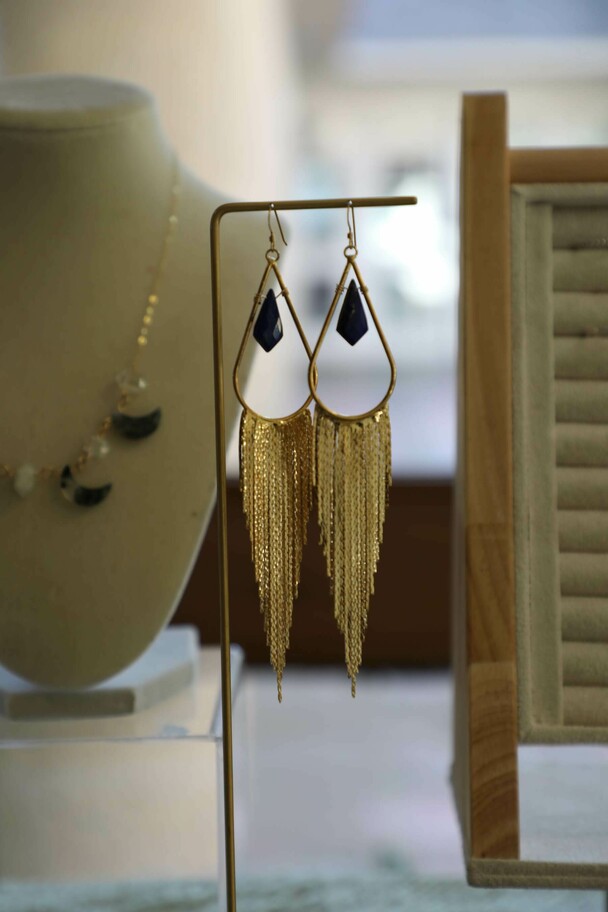 Dangle earrings displayed on a table with additional pieces of jewelry.