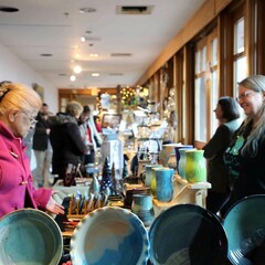 Winter Fair guest peruses table display of pottery.