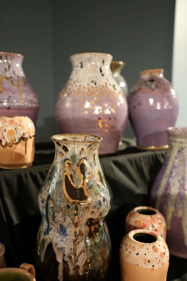 Multiple pieces of pottery on tiered shelves.