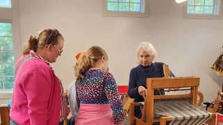 Guests watch a volunteer process wool.