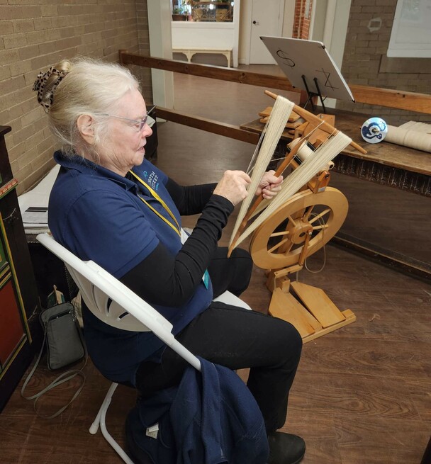 Volunteer processes wool.