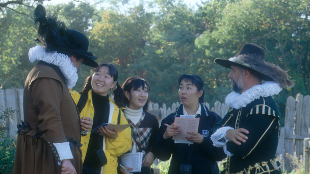 Two pilgrims with group of guests chatting