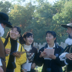 Two pilgrims with group of guests chatting