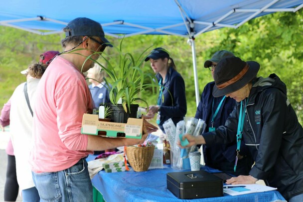 Visitor purchasing plants from Plimoth Patuxet employees at the Plant Sale