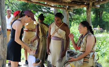 Mother and child guest engage with Educators at the Shade Arbor on the Historic Patuxet Homesite