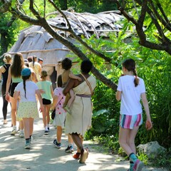 Line of guests and Museum Educators enter the wetu on the Historic Patuxet Homesite