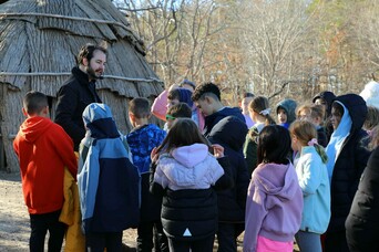 Museum guide provides tour of the Historic Patuxet Homesite to a group of children on a field trip.