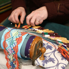 An artisan at the Winter Fine Arts & Craft Fair demonstrates how to make intricate lace patterns using bobbins.