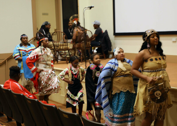 Members of Wetu Ways demonstrate a dance in front of the stage in Plimoth Cinema.