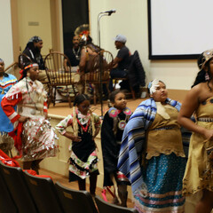 Members of Wetu Ways demonstrate a dance in front of the stage in Plimoth Cinema.