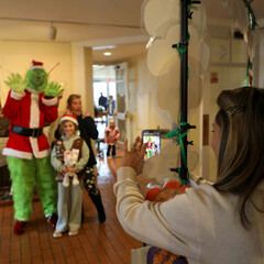 A mother snaps a photo of her daughters posed with the Grinch before the Moo-flower.