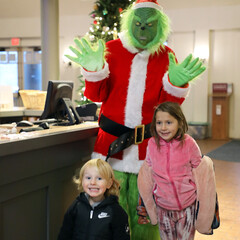 Grinch poses with two children at Plimoth Patuxet during the Matinee event.