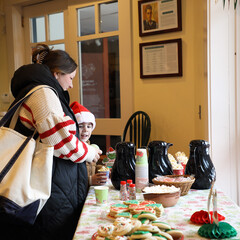 Mother and child peruse holiday cookies, hot cocoa, and other treats.