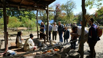 Guests gathering around cooking arbor on Historic Patuxet Homesite to engage with Educators.