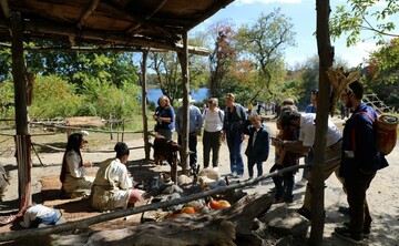 Guests gathering around cooking arbor on Historic Patuxet Homesite to engage with Educators.