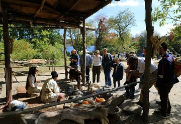 Guests gathering around cooking arbor on Historic Patuxet Homesite to engage with Educators.
