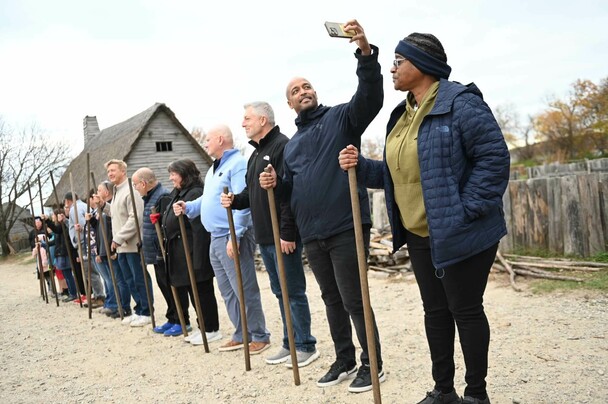 Group of adults in Muster drill. One man has a raised arm to take a selfie.
