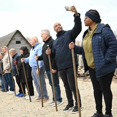 Group of adults in Muster drill. One man has a raised arm to take a selfie.