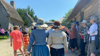 Two pilgrims walk through crowd while linking arms